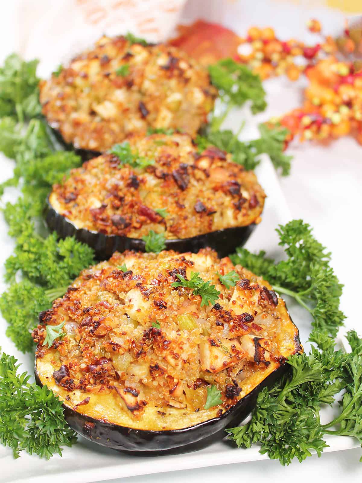 3 Vegetarian Stuffed Acorn Squash on a platter with parsley.