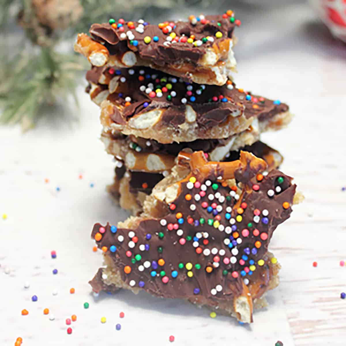 Chocolate Bark with pretzels stacked on white table.