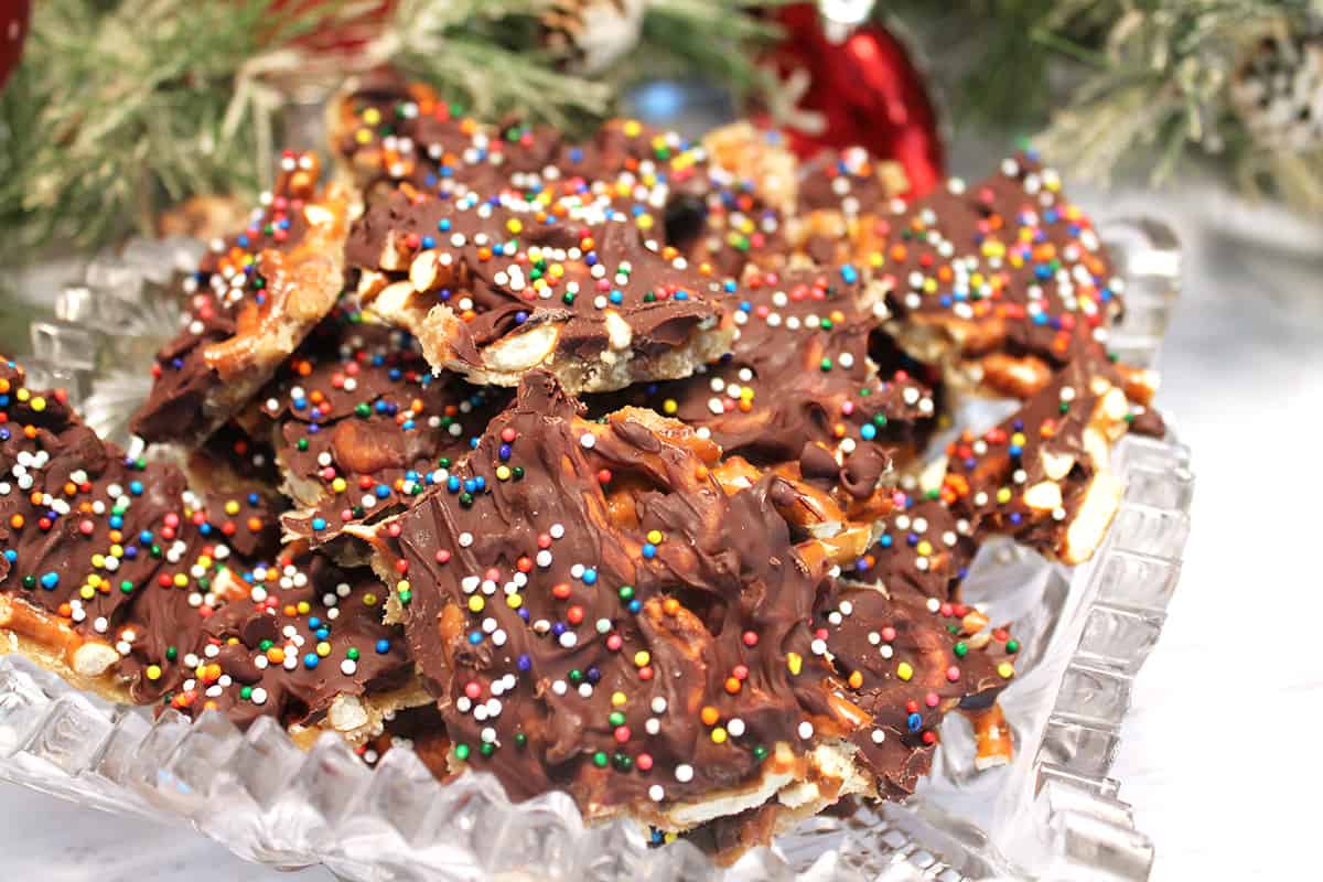 Closeup of cracked Christmas Bark with pretzels in crystal bowl.