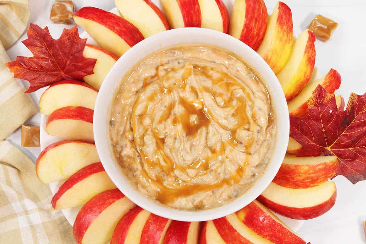 Overhead closeup of caramel apple dip with cream cheese in bowl.