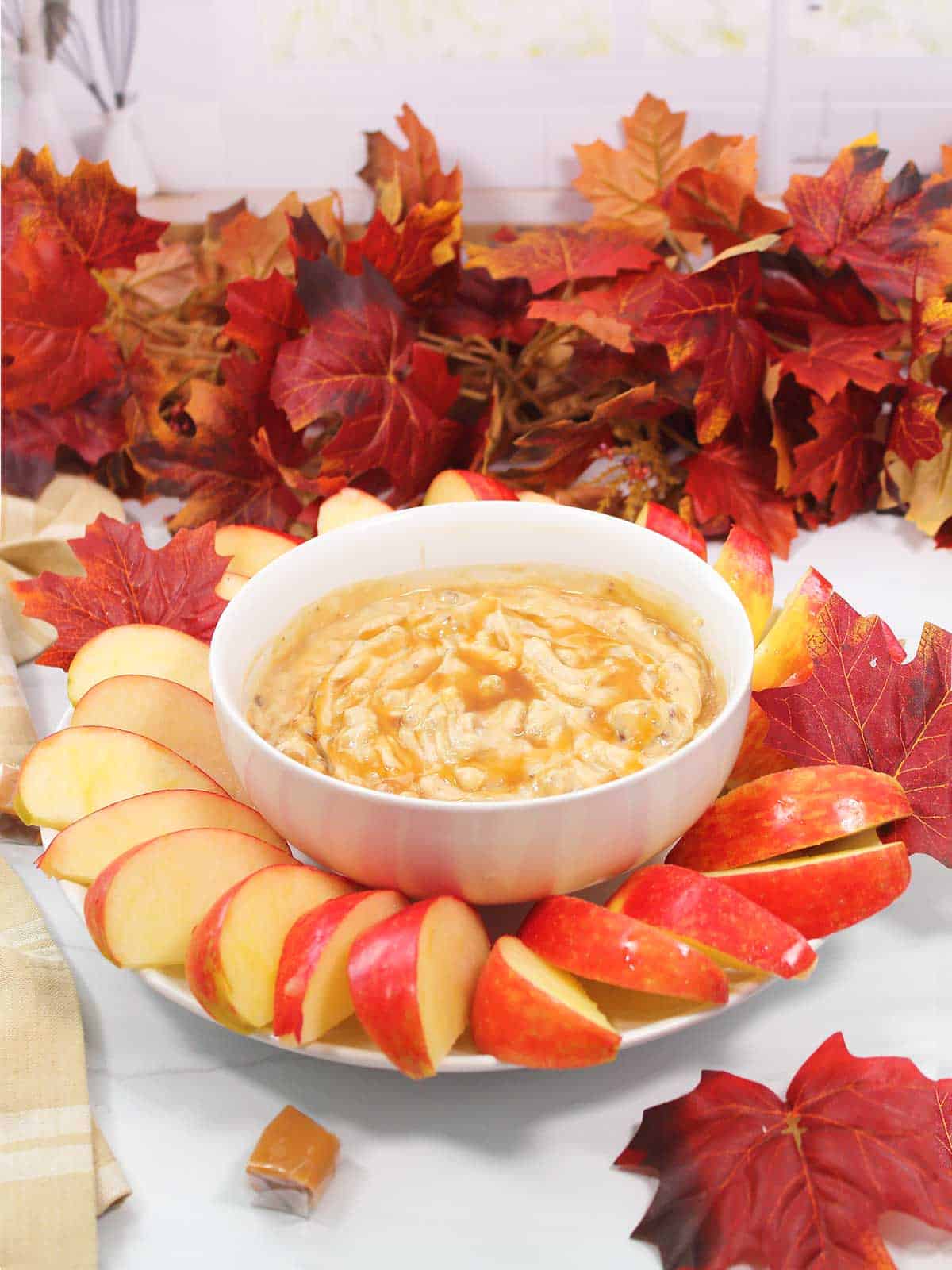 Cream Cheese Caramel Apple Dip surrounded by apple slices.