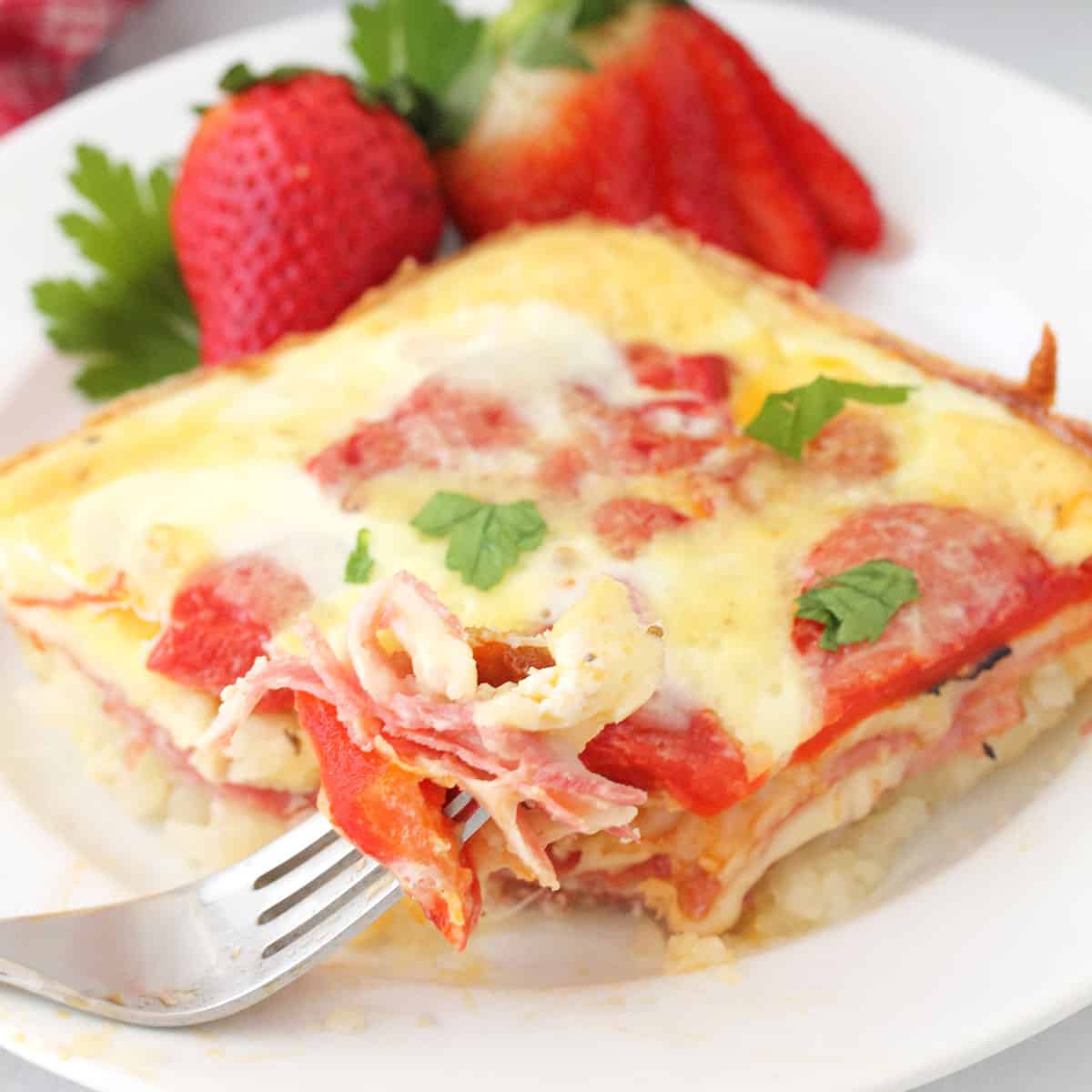 Closeup of Italian Egg Bake on white plate with bite on fork.
