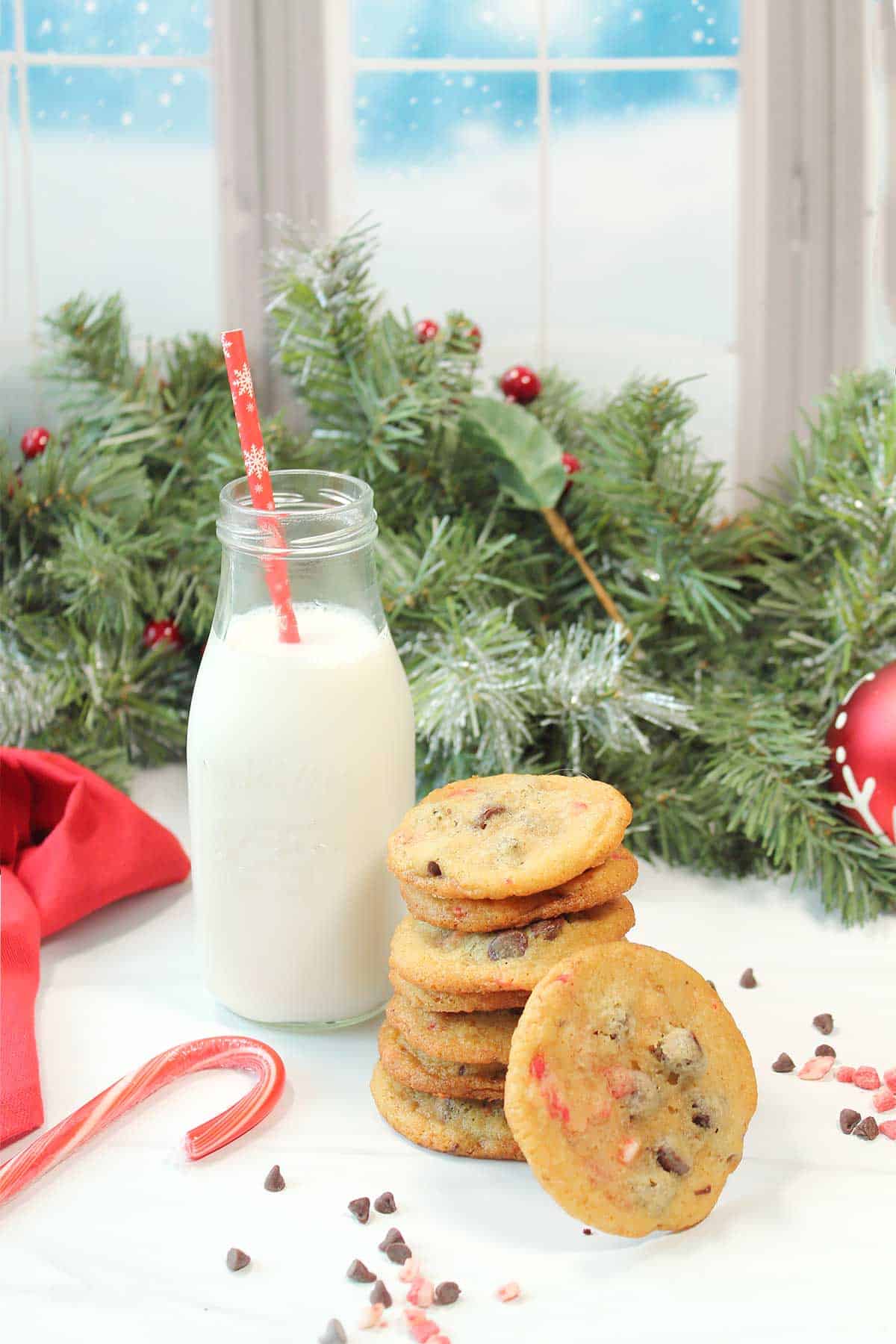 Peppermint chocolate chip cookies stacked by milk bottle.