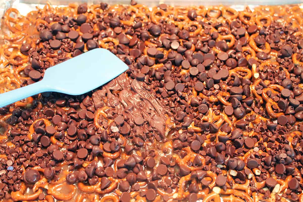Apreading melted chocolate over toffee.