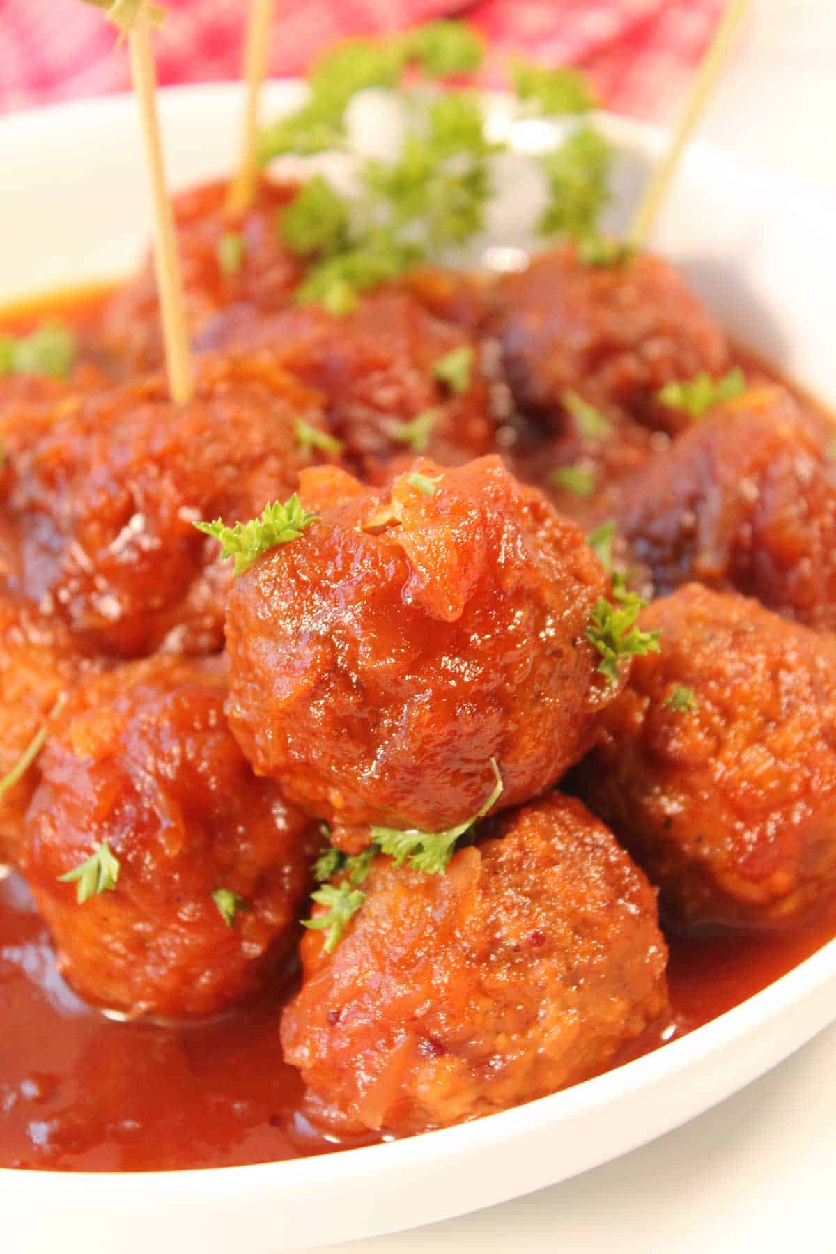 Closeup of cranberry sauce meatballs in bowl.