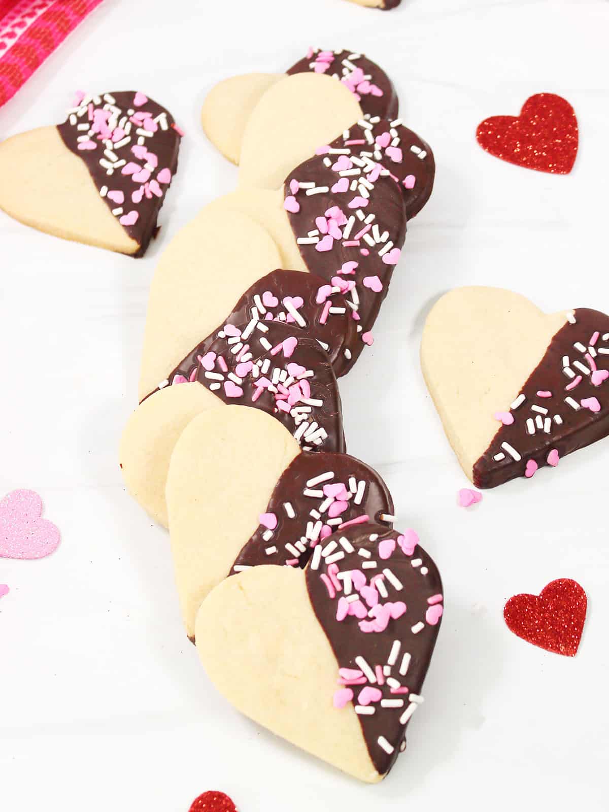 Valentine chocolate dipped cookies on white table.