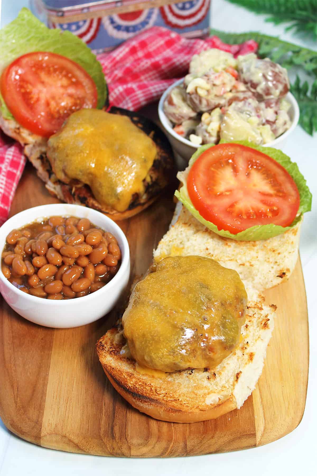 Chorizo burgers with sides on wooden board.