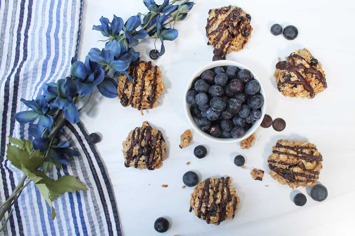 Cookies around bowl of blueberries.