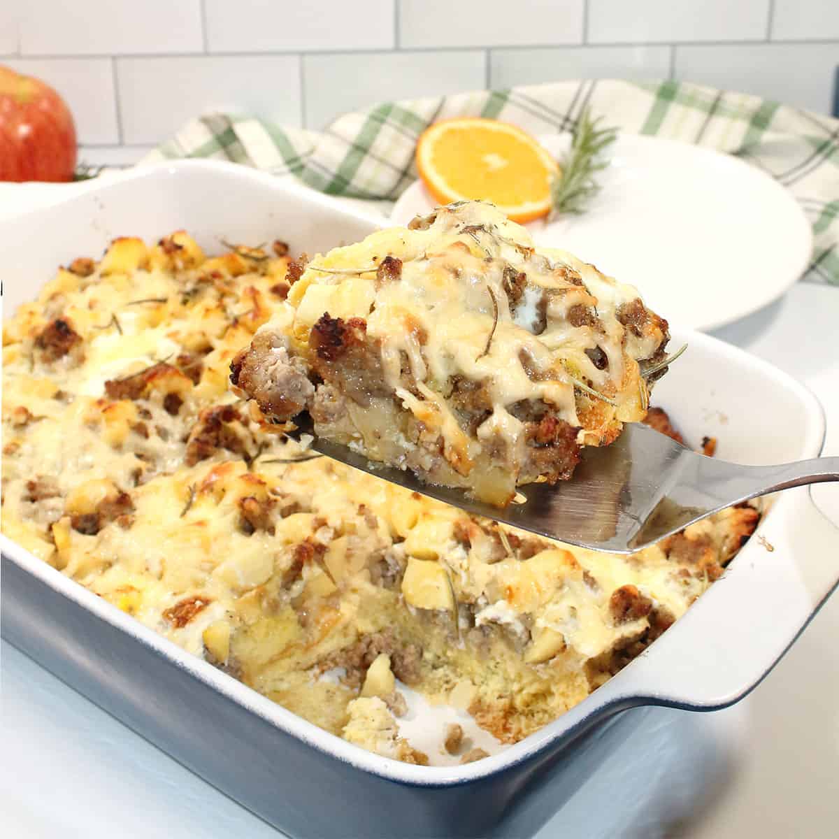 Liftin slice of sausage breakfast casserole out of dish.