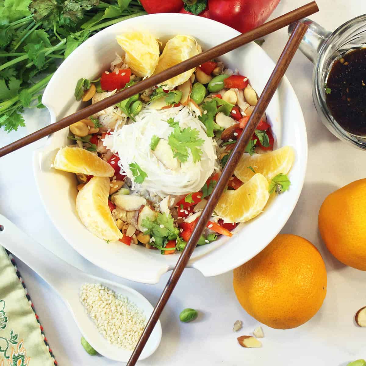 Overhead of salad with chopsticks and sesame on spoon beside it.