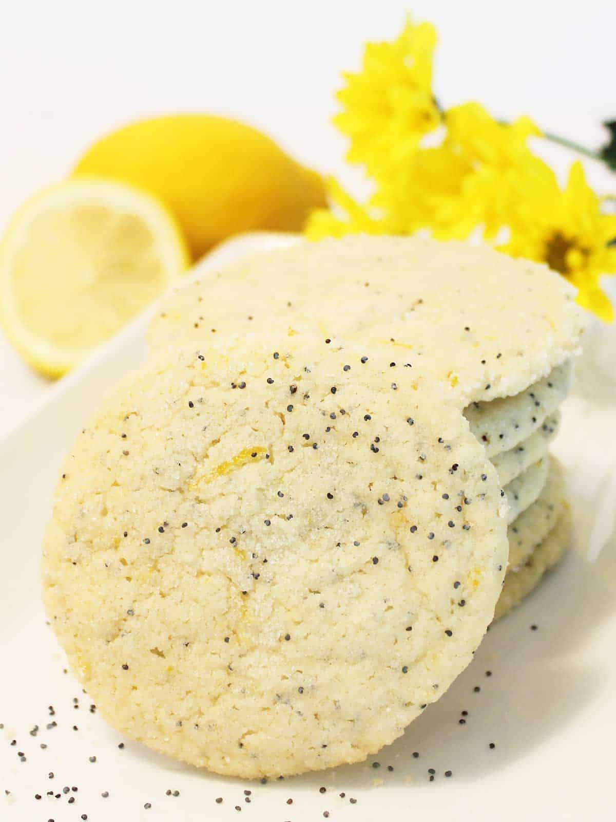 Lemon Poppy Seed Cookies stacked on platter with one in front.