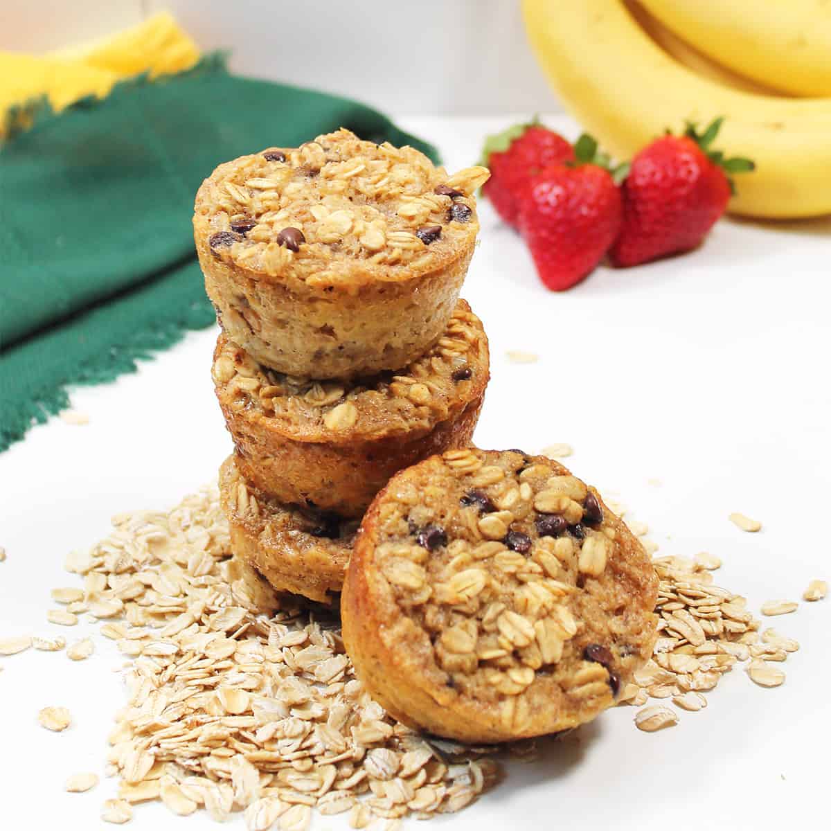 Stack of muffins with bananas and strawberries.
