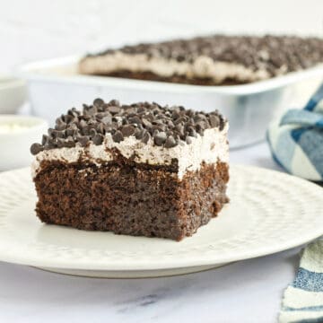 Chocolate poke cake slice on plate.