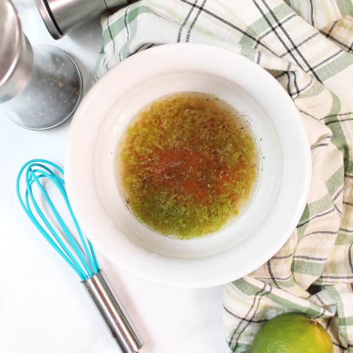 Lime dressing mixed in white bowl.
