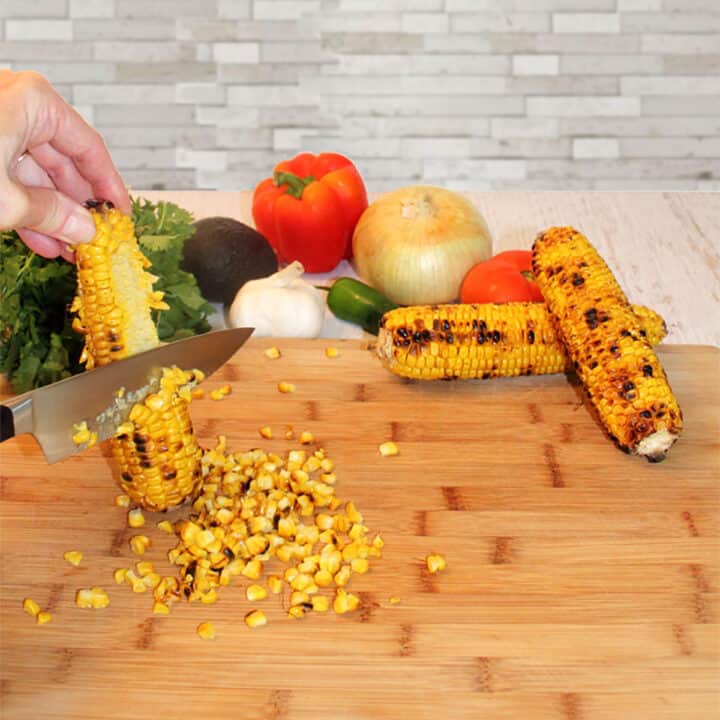 Cutting grilled corn off the cob.