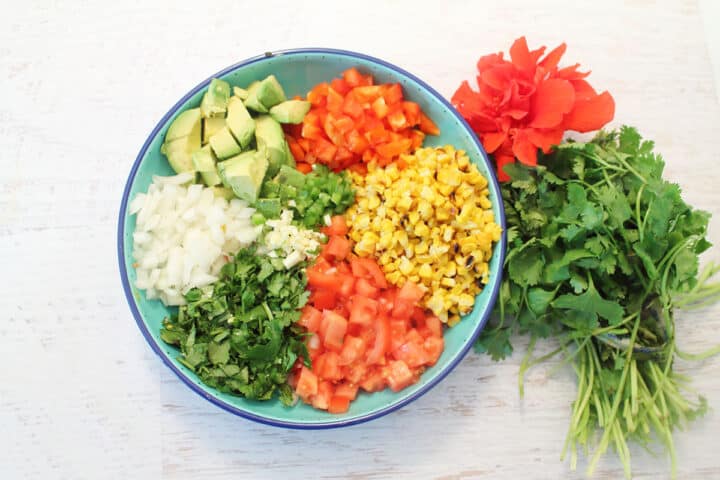 Salad ingredients laid out in blue bowl.