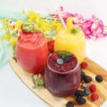 Three flavors of alcoholic slushies on wooden tray.