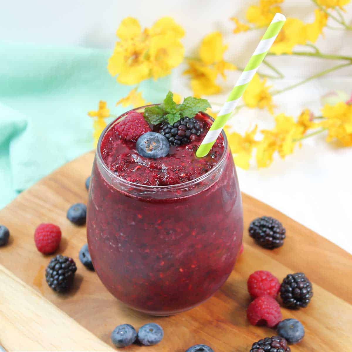 Triple berry wine slushie in glass with straw.