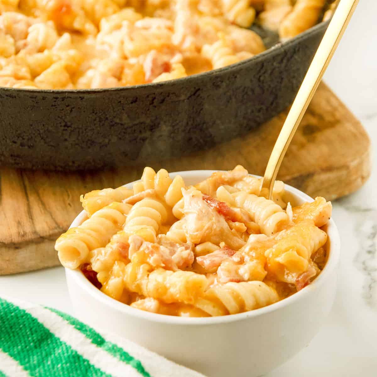 Chicken Bacon Mac and Cheese is bowl with skillet in back.