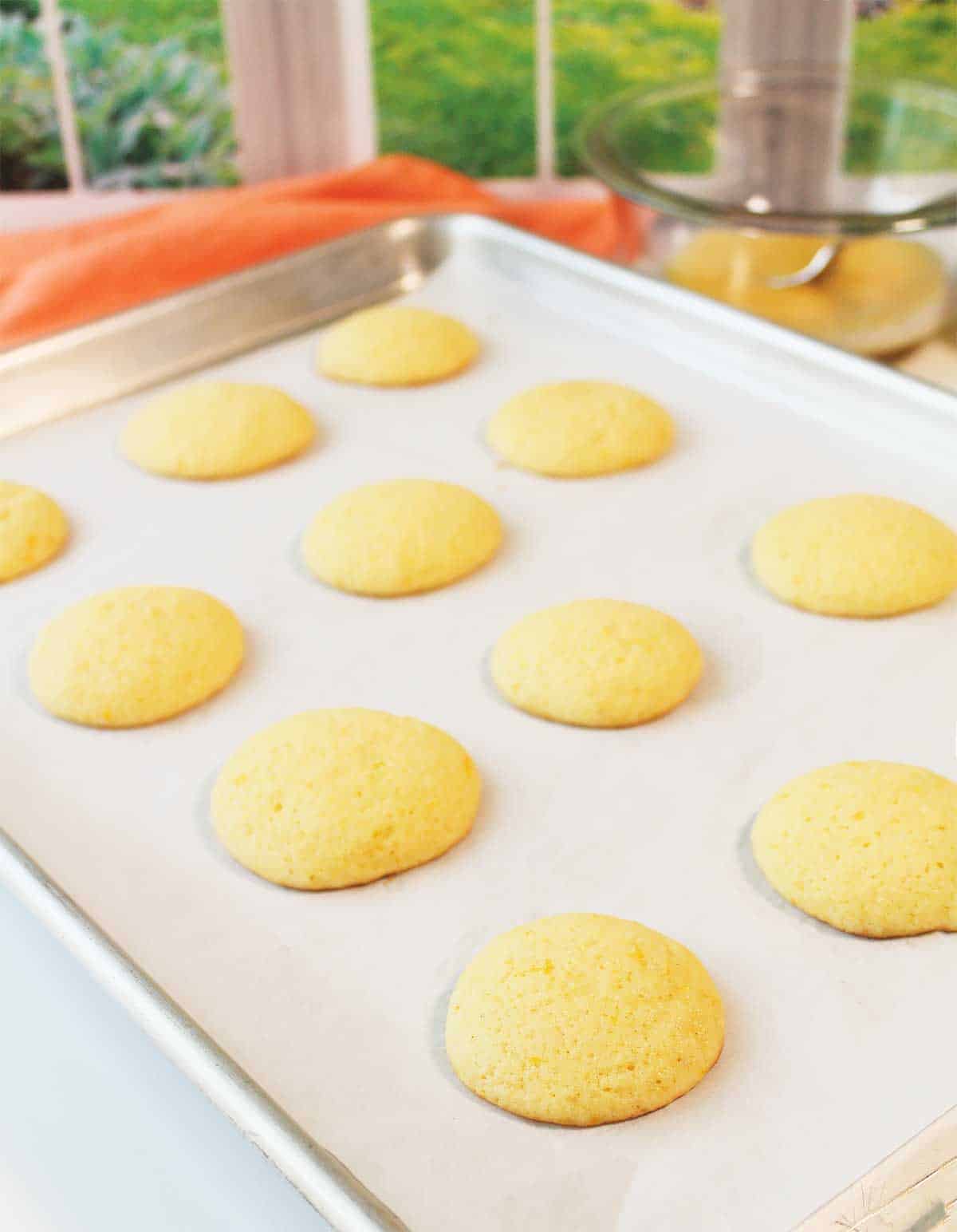 Baked orange cookies on cookie sheet.