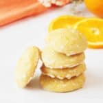 Stack of orange cookies with orange icing.
