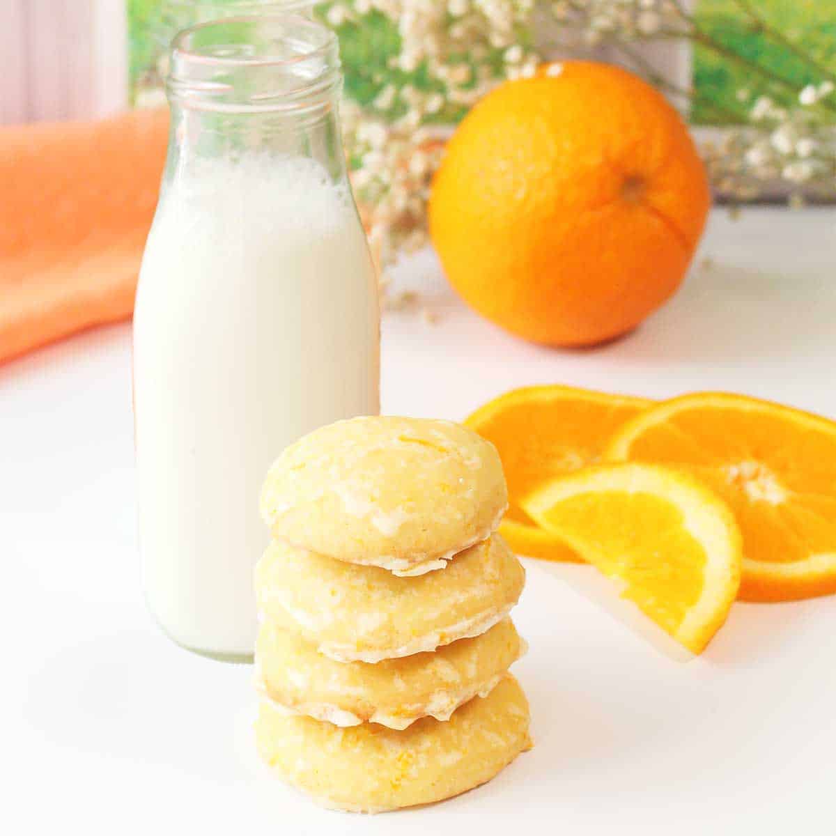 Orange creamsicle cookies stacked by milk bottle.