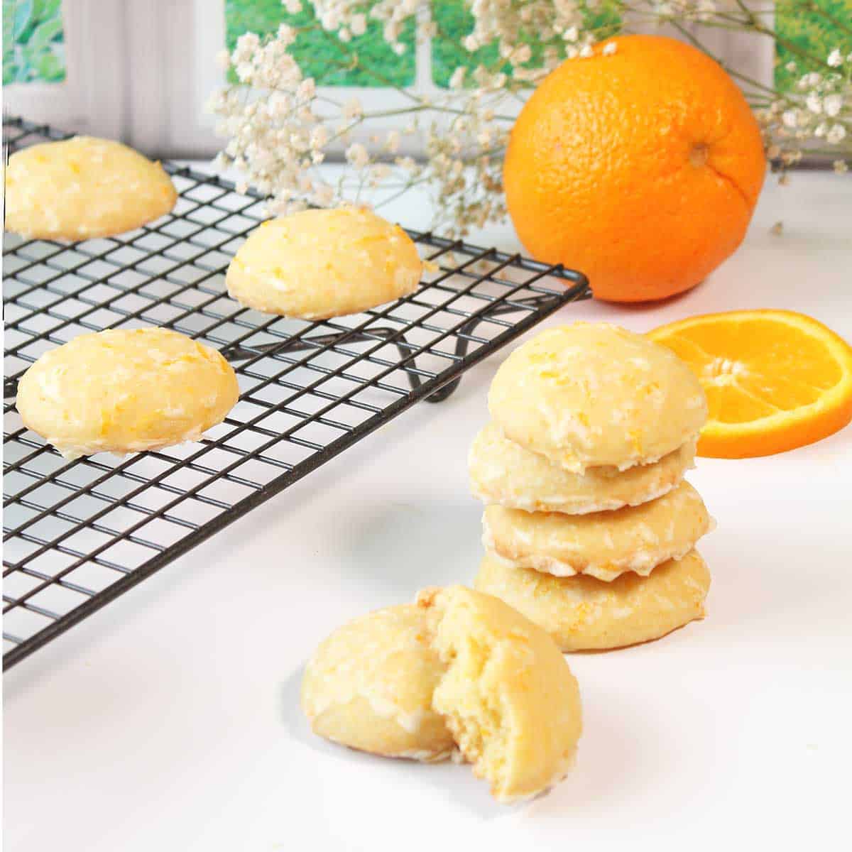 Creamsicle cookies stacked and on wire cooling rack.