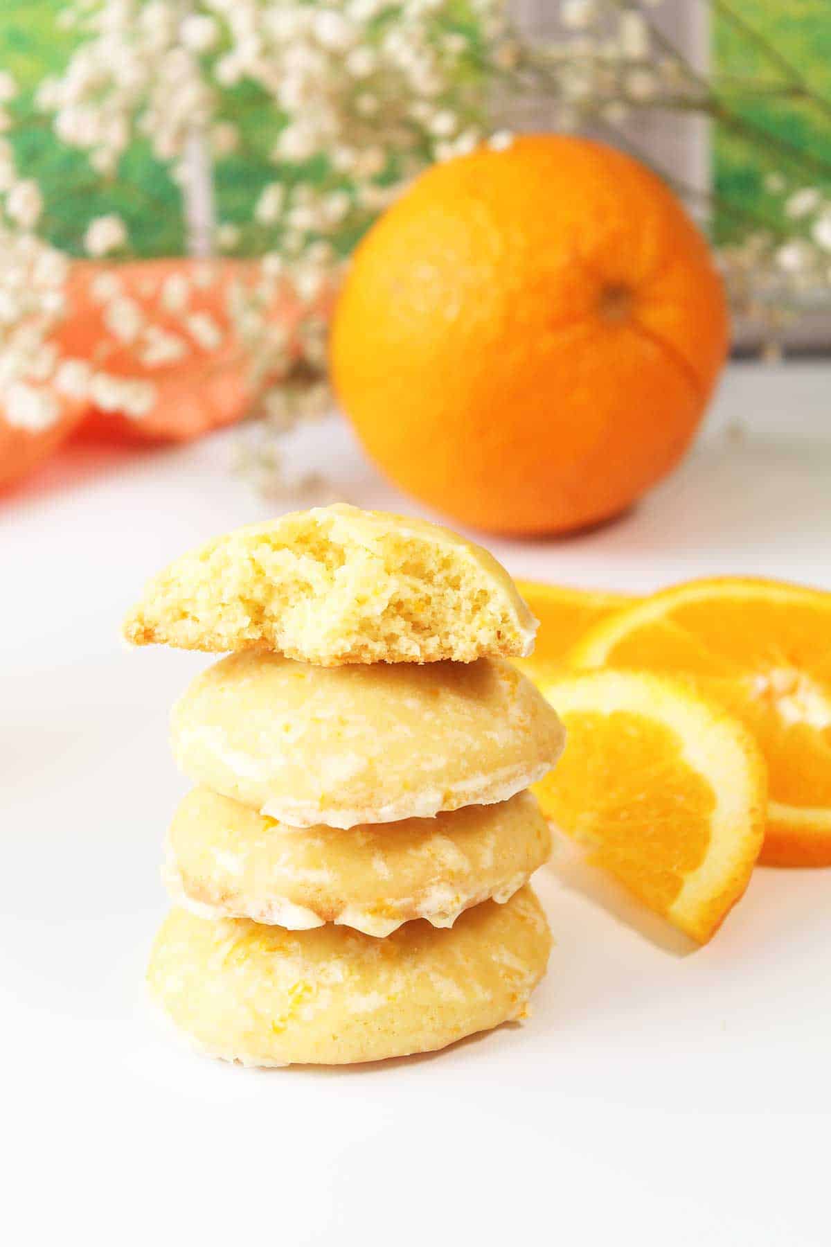 Orange creamsicle cookies stacked with halved one on top.