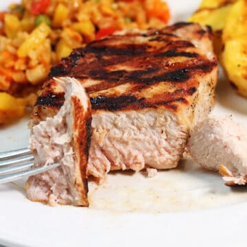 Bite of grilled pork on fork.