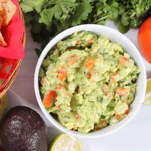 Classic Guacamole in bowl next to chips.