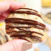 Holding cookie with cookies in background.