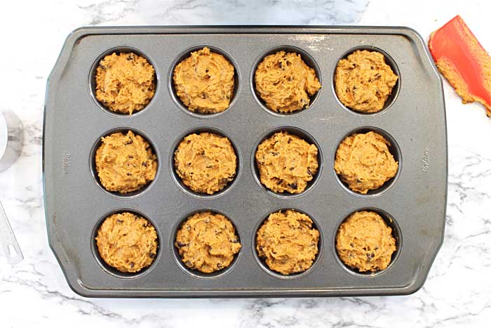 Muffins in muffin tin ready for crumbs.