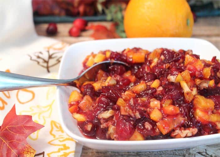 Cranberry Orange Relish in white bowl with spoon in it.