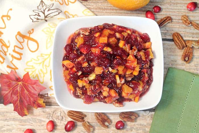 Overhead of cranberry relish in white bowl with Thanksgiving towel.