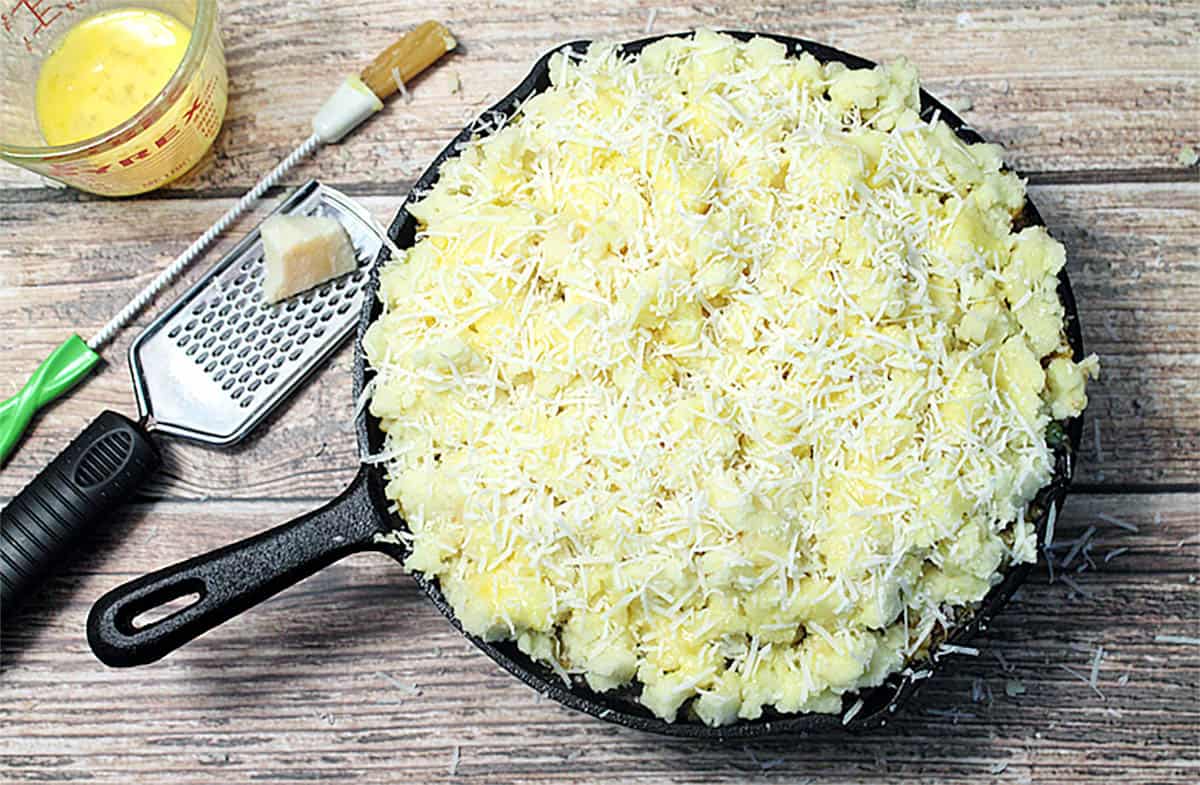 Sprinkling top of potatoes with cheese.