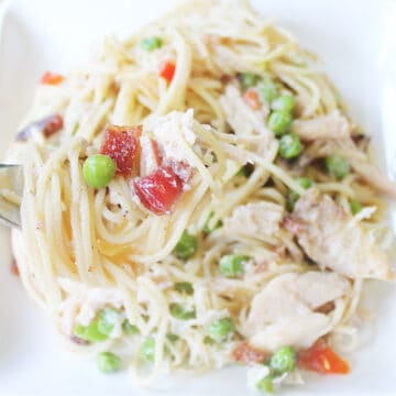Closeup of pasta with turkey on plate with bite on fork.