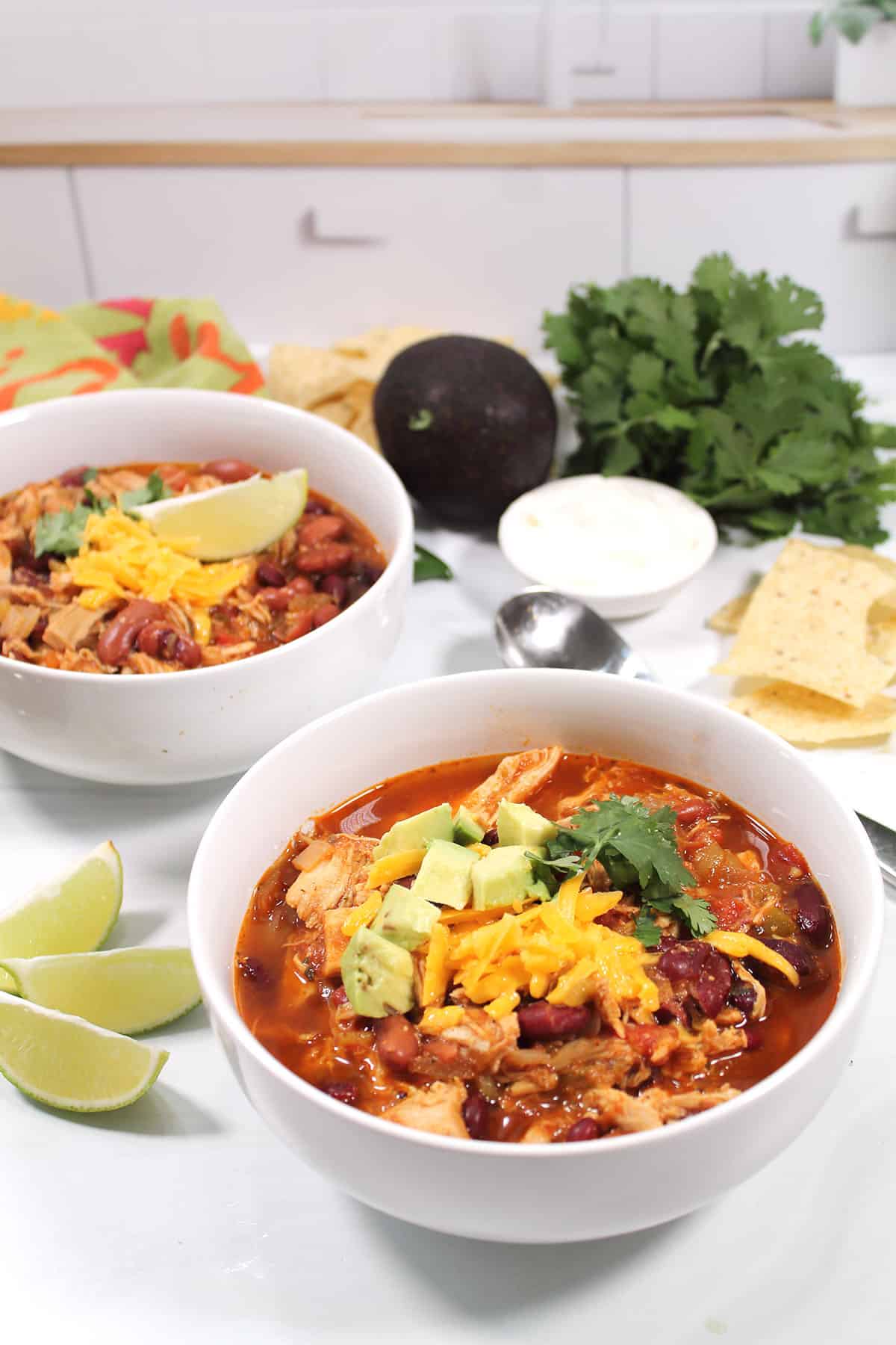 Two bowls of chili with limes.
