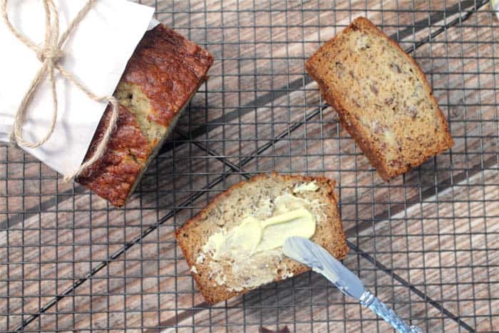 Spreading honey butter on slice of bread on wire rack.