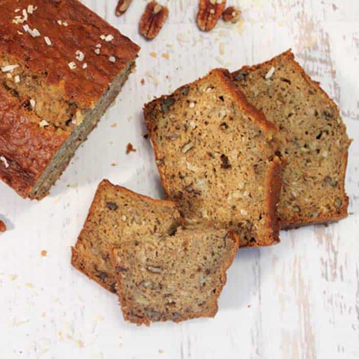 classic banana bread sliced on white wooden table.
