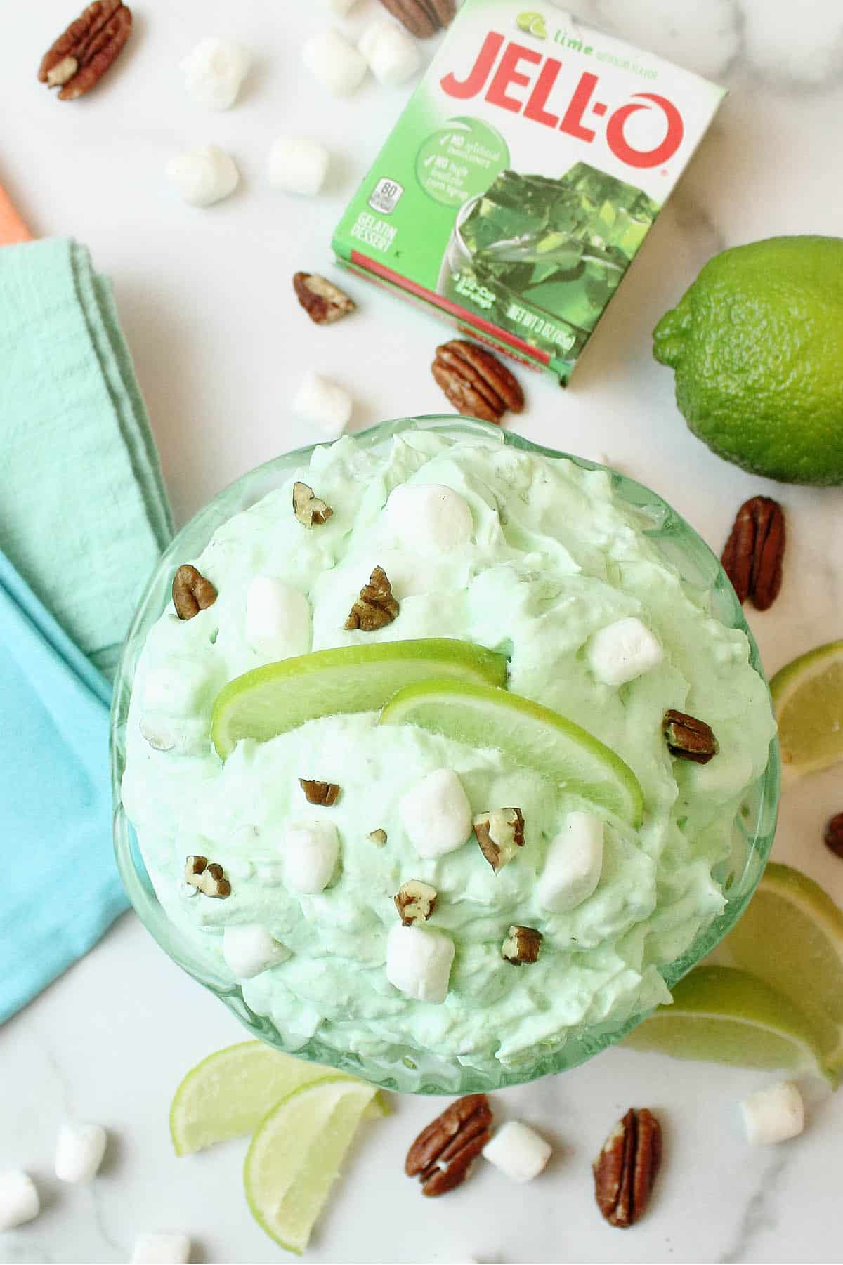 Overhead of bowl of lime fluff with lime jello package beside it.