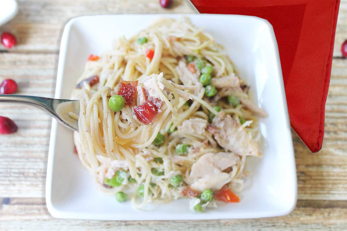 Pasta on fork over white plate of turkey pasta.