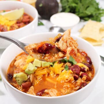Spoonful of chili over bowl.