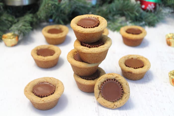 Stack of finished peanut butter cup cookies by greenery.