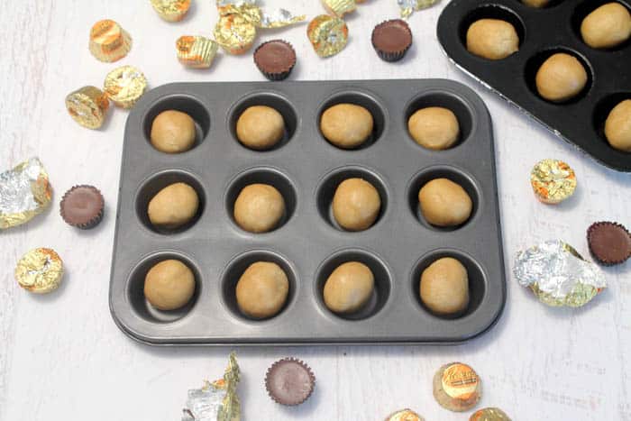 Preparing cookie cups by pressing into muffin pan.
