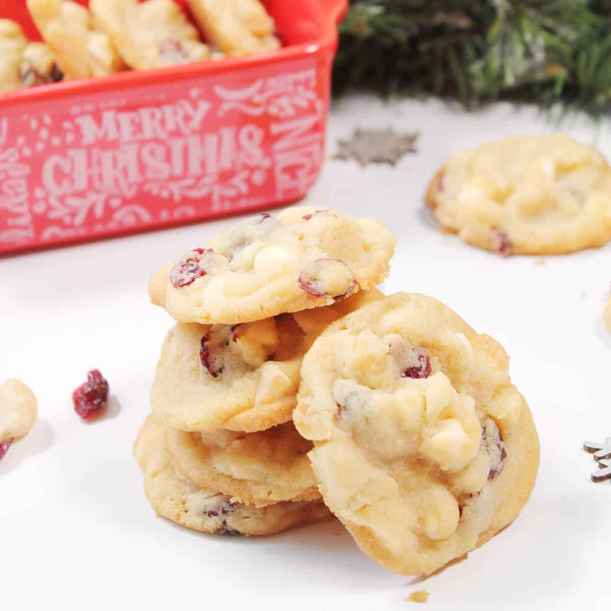 Stack of cookies with Christmas dish in back.