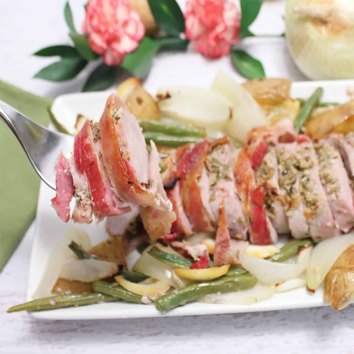 Lifting slices of pork from platter.