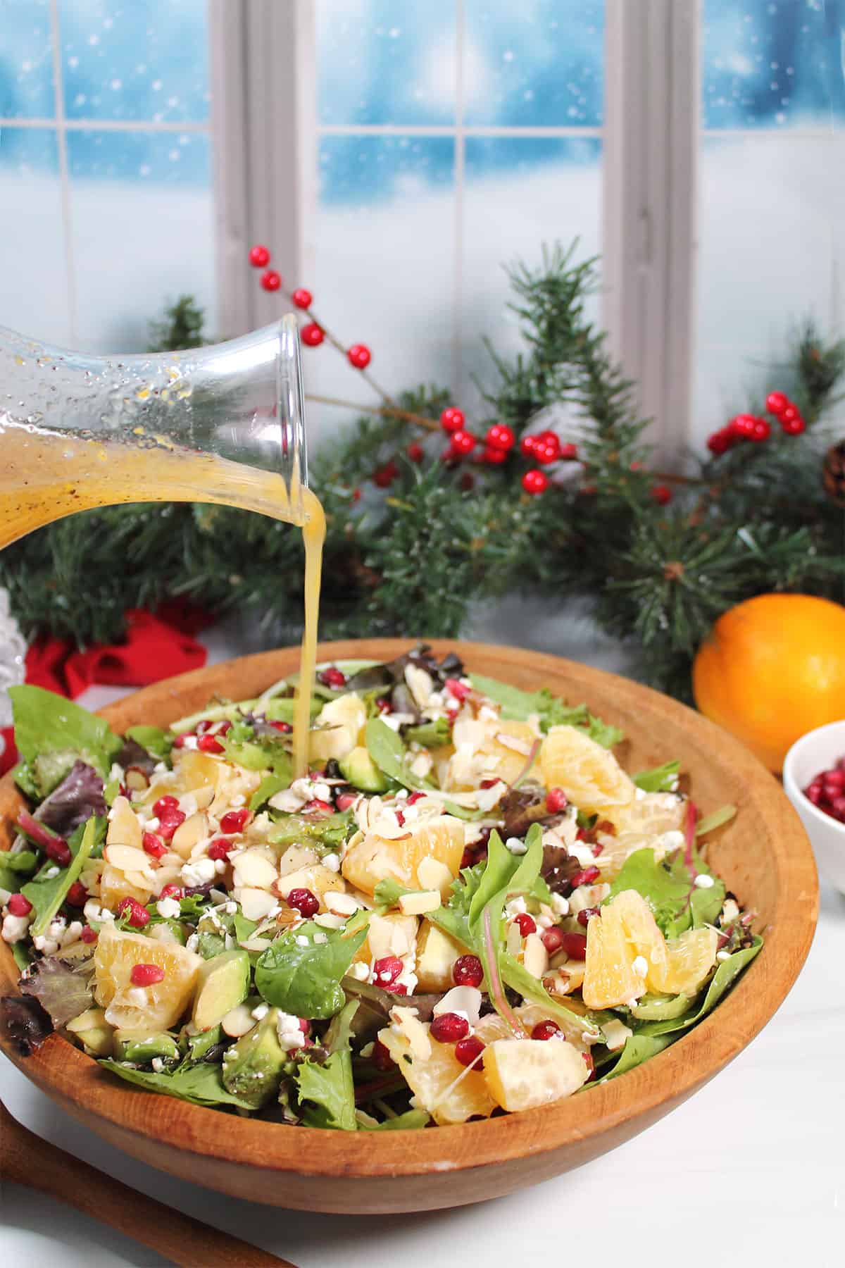 Drizzling orange vinaigrette over orange pomegranate salad.