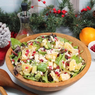 Orange Pomegranate Salad tossed in wooden salad bowl.