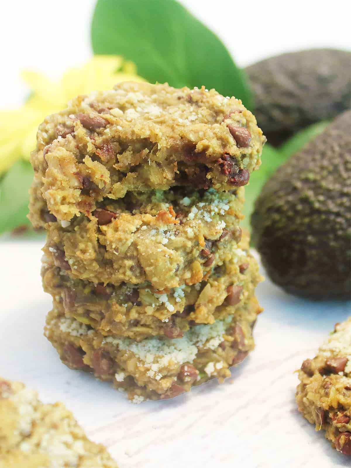 Vegan oatmeal chocolate chip cookies stacked with bite taken out of top one.