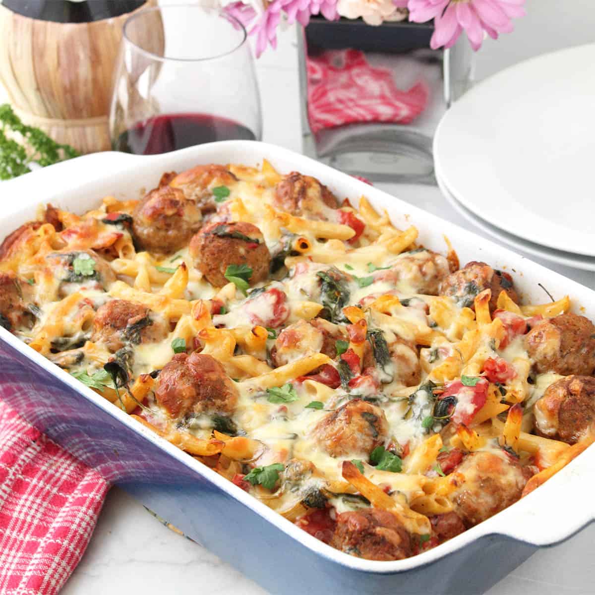 Baked meatball casserole with wine and flowers.